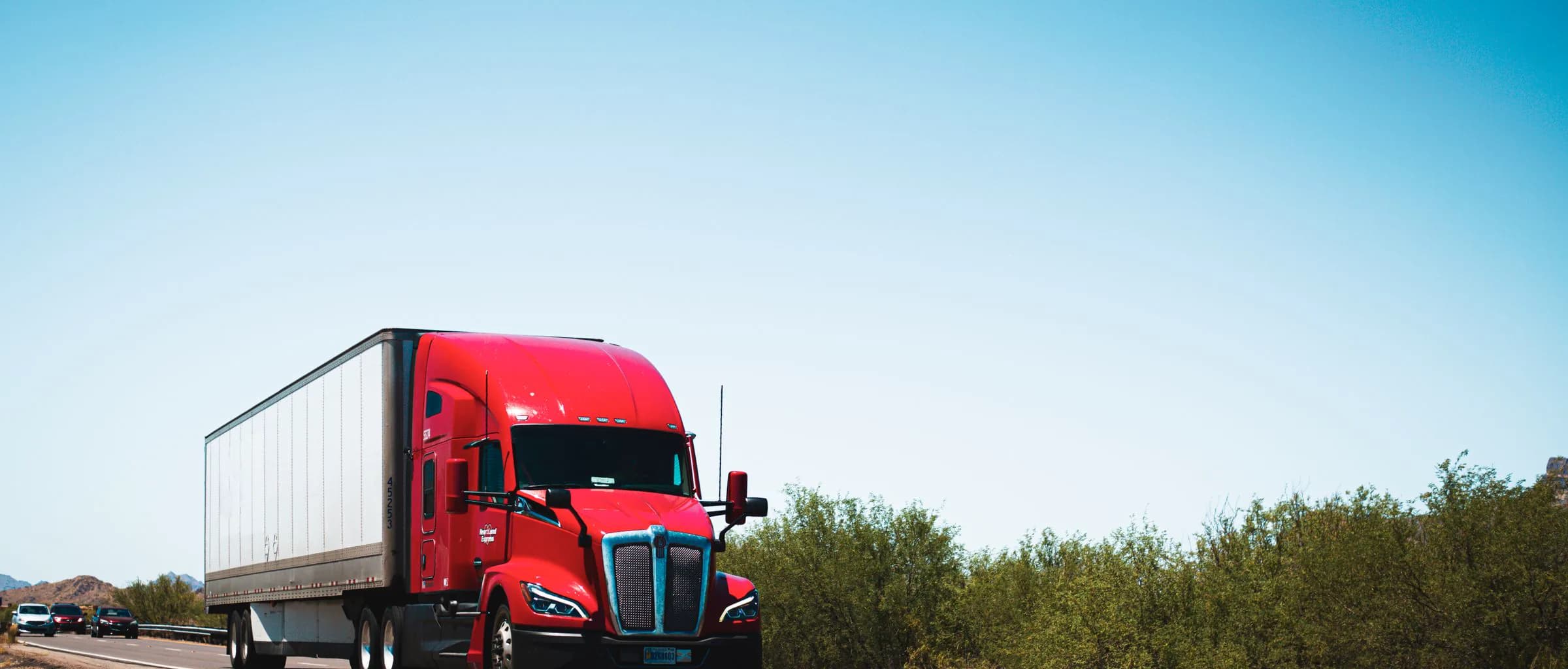 Glossy red Kenworth semi-truck on the highway